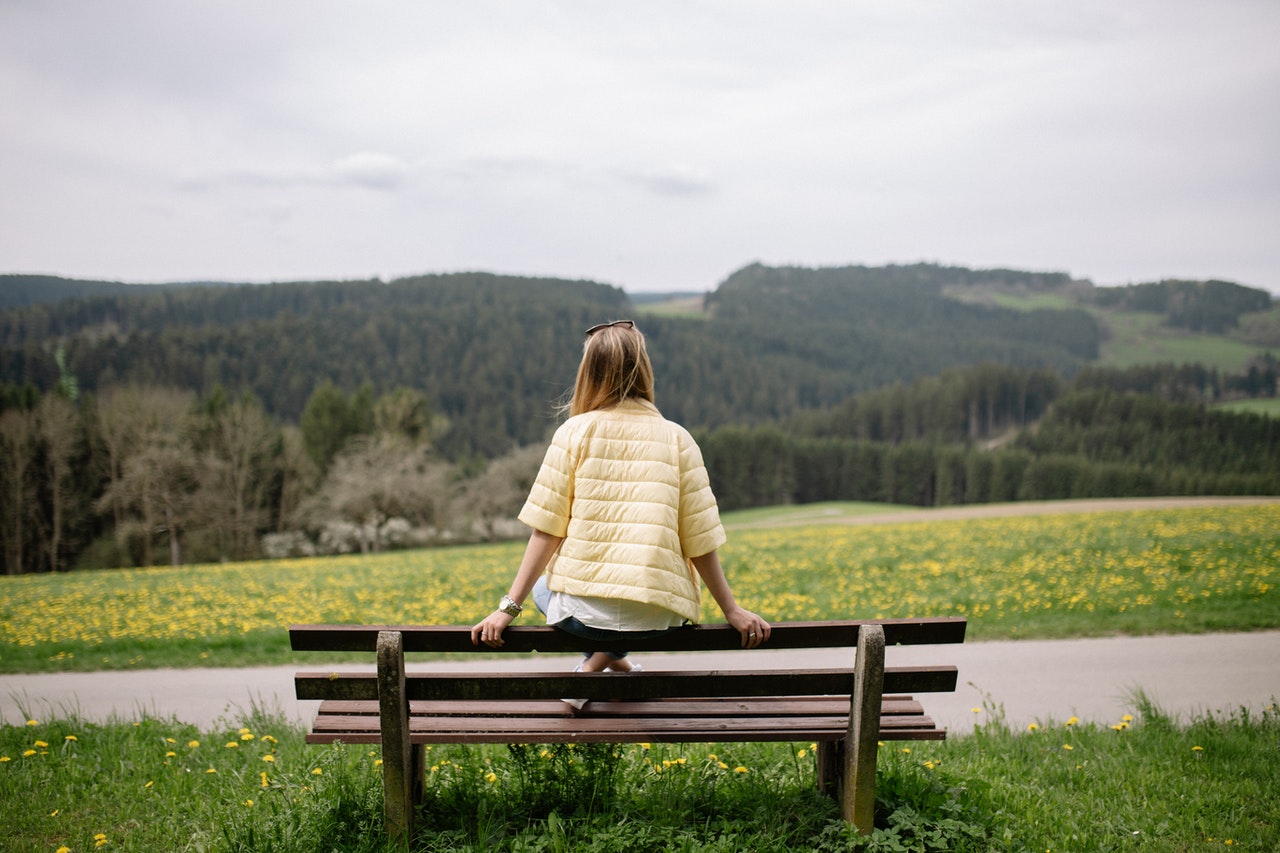 woman sitting on bench praying